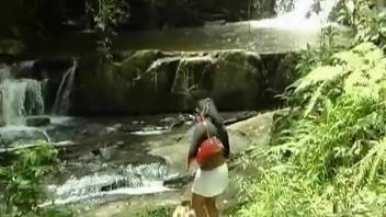 Dog fucks a curvy Latina by the desolate waterfall